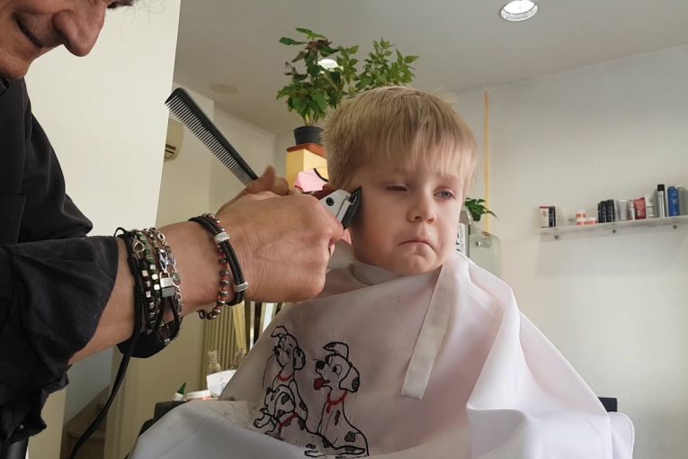 малыш старается не  заплакать в парикмахерской